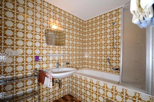 朗根费尔德里姆尔旅馆的浴室配有盥洗盆和浴缸。
