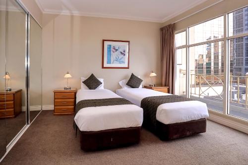 墨尔本弗林德斯兰丁公寓的酒店客房设有两张床和大窗户。