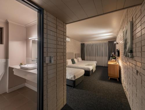 悉尼Palms Hotel的酒店客房设有两张床和盥洗盆