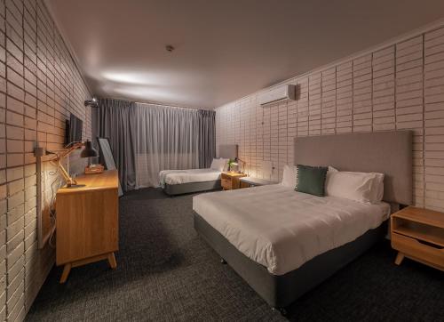 悉尼Palms Hotel的酒店客房设有两张床和电视。