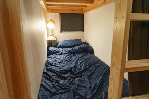 Saikiゲストハウス さんかくワサビ的小房间的小床,带梯子