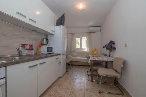 博格莫耶Apartments Ante的带小桌子的厨房和带白色橱柜的厨房