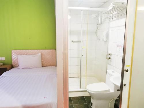 古晋Homestay Kuching Hotel的一间带一张床、淋浴和卫生间的浴室