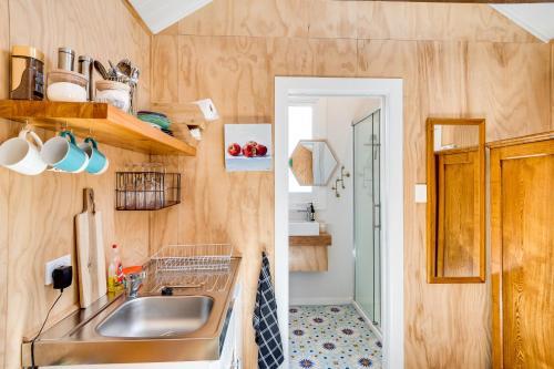纳皮尔Ahuriri Studio Cottage的一个带水槽和镜子的小厨房