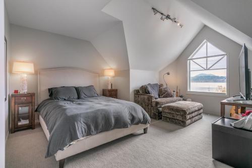 基洛纳Kelowna Discovery的卧室配有床、椅子和窗户。