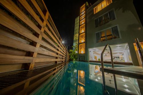 高尔de MODA Boutique Hotel Galle的一座游泳池,在晚上在建筑物前