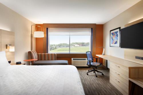 威廉斯堡Holiday Inn Express Williamsburg, an IHG Hotel的配有一张床、一张书桌和一扇窗户的酒店客房