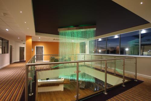 亨廷登亨廷登赛马场假日酒店的一座带游泳池的建筑中的玻璃楼梯