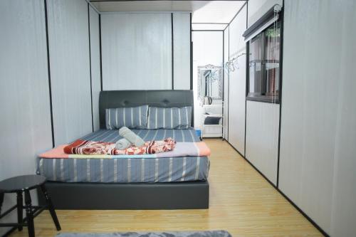 巴东勿刹Padang Besar Red Cabin Homestay的卧室中间设有一张床