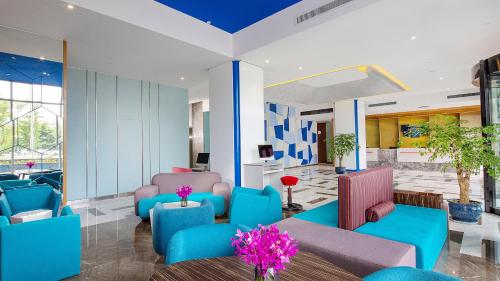 绵阳绵阳高新智选假日酒店的大堂设有蓝色和粉红色的椅子和桌子