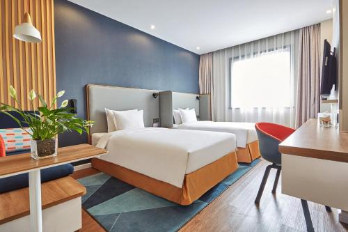 南京南京玄武湖智选假日酒店的酒店客房配有两张床和一张书桌