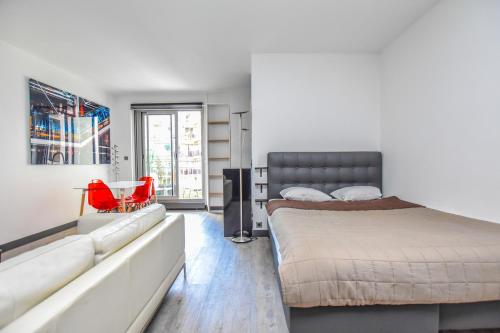 La VerrerieLuxe Neuilly s/ Seine的一间卧室配有一张大床和红色椅子