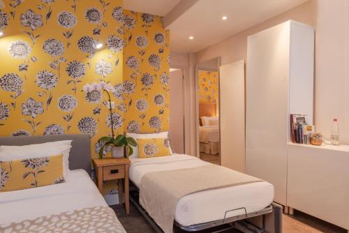 巴黎29乐匹克酒店的一间卧室设有两张床和黄色的墙壁