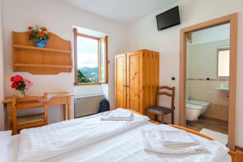 阿维奥巴尔多山旅馆的一间卧室配有一张床,浴室设有浴缸