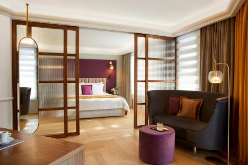 塞萨洛尼基The Excelsior Small Luxury Hotels of the World的配有一张床和一把椅子的酒店客房