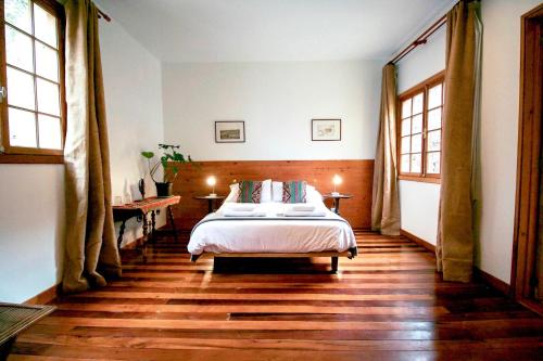 瓦尔帕莱索Casa California Guesthouse的卧室配有一张床、木地板和窗户。