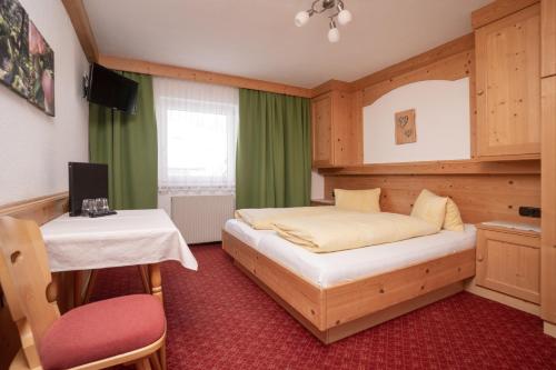 索尔登阳光家庭旅馆的一间卧室配有一张床、一张桌子和一张书桌
