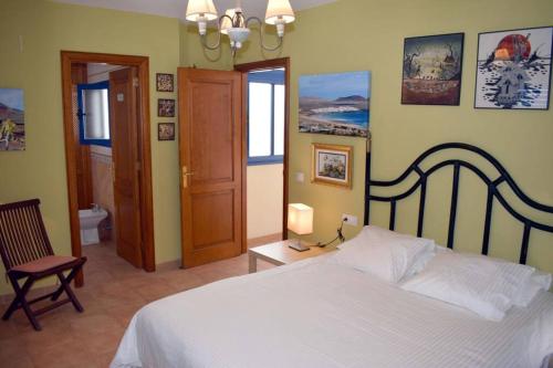 法马拉Lanzarote Famara Beach的卧室配有白色的床和椅子