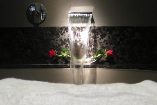 开普敦开普敦大西洋景精品酒店的浴室柜台上装有鲜花的水水龙头