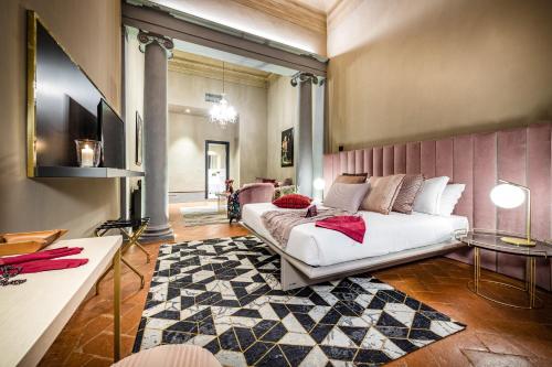 佛罗伦萨Palazzo Bianca Cappello Residenza d'Epoca的卧室配有白色的床和地毯。