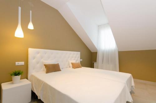 AraguásCasa Rural La Esencia的卧室配有一张带两个枕头的大白色床
