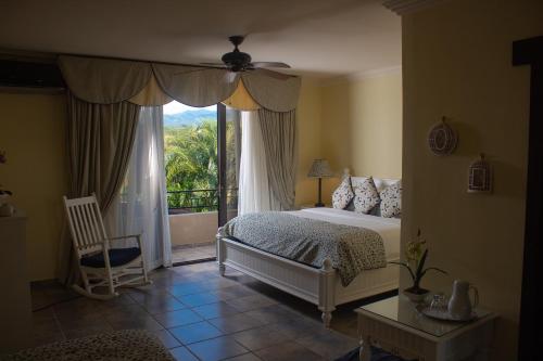 下博克特Hacienda Los Molinos Boutique Hotel & Villas的一间卧室设有一张床和一个大窗户