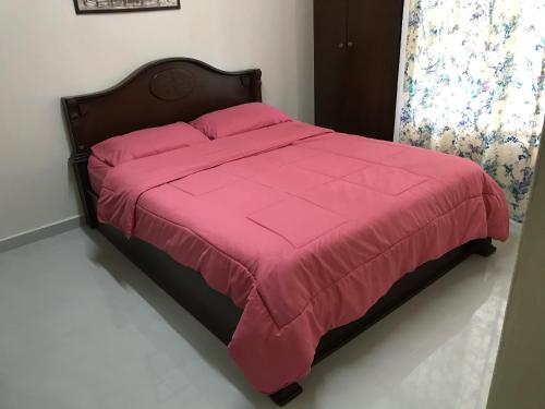 Kampong Baharu Sungai Way苏邦维尔伊赫桑公寓的卧室内的一张带粉红色棉被的床