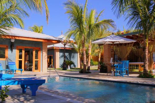 奥林匹亚Thermas Park Resort & SPA by Hot Beach的一座房子,设有一座带蓝色椅子和遮阳伞的游泳池