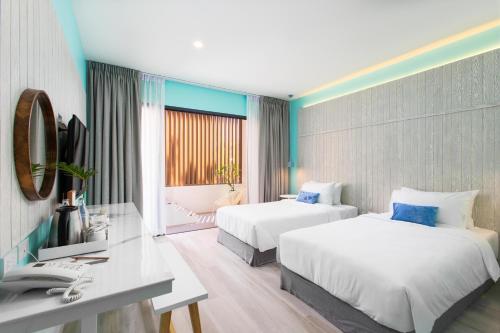 拉廊Sook Hotel的酒店客房配有两张床和一张书桌