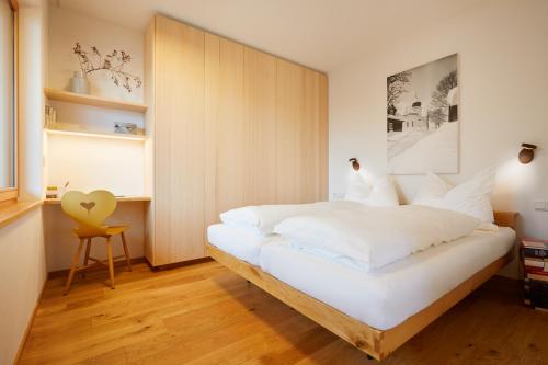 达米尔斯Landhaus Bergpanorama TOP 7的卧室配有白色的床和黄色椅子