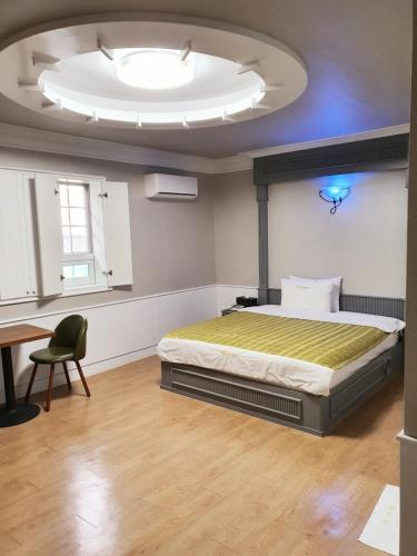 庆州山地汽车旅馆的一间卧室设有一张床和大型天花板