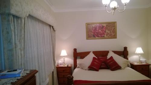 吉斯伯恩克莱哥特庄园旅馆的一间卧室配有红色枕头的床