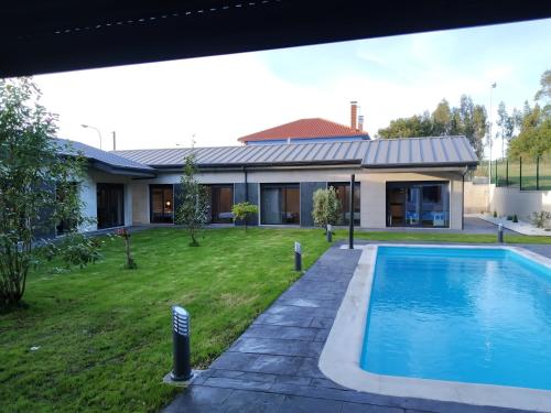 阿尔苏阿Carballos Altos-Apartamentos Turísticos的庭院中带游泳池的房子