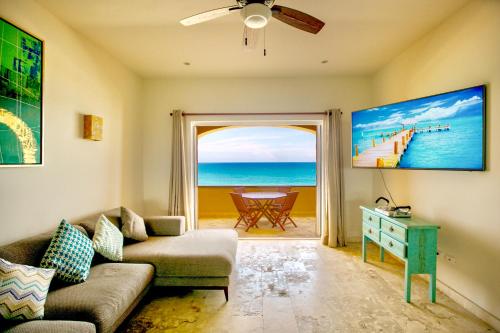 女人岛Joe‘s Condo at Isla 33的带沙发的客厅,享有海滩美景