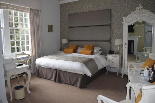 伯恩茅斯朗特里庄园酒店的一间卧室设有一张大床和一个大镜子