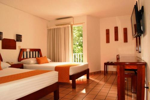帕伦克Hotel Maya Palenque的酒店客房设有两张床和窗户。
