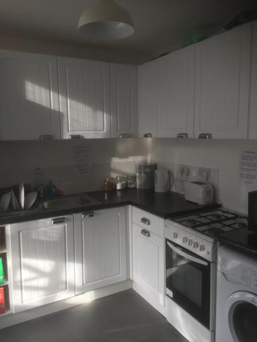 邓迪Scotland Beds的厨房配有白色橱柜和炉灶烤箱。