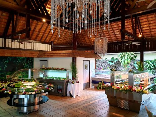 波拉波拉Maitai Bora Bora的一间提供自助餐的餐厅,在房间内种有鲜花