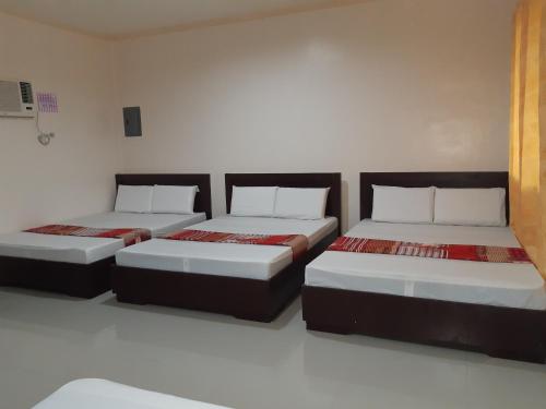 曼巴豪Veance Travellers Inn-Pabuas extension的一间客房内配有两张床的房间