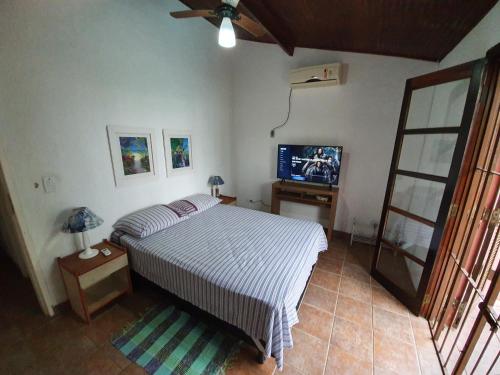 圣塞巴斯蒂安Casa pé na areia em Toque Toque的一间卧室配有一张床和一台平面电视