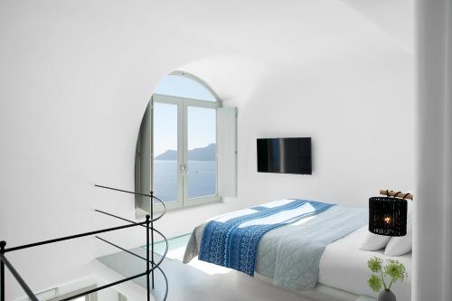 伊亚La Perla Villas and Suites - Adults Only的白色卧室配有床和镜子