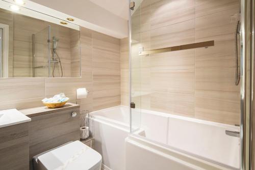布莱克浦Burbage Holiday Lodge Apartment 6的带浴缸、卫生间和淋浴的浴室。