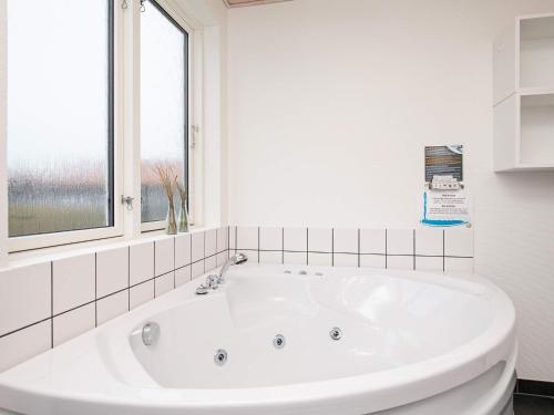 乌尔夫堡6 person holiday home in Ulfborg的带窗户的浴室内的白色浴缸