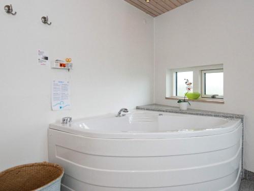 埃贝尔托夫特8 person holiday home in Ebeltoft的带窗户的浴室内的白色浴缸