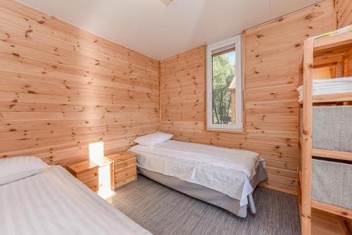 迪勒维尔纳Drevernos kempingas的木墙客房的两张床