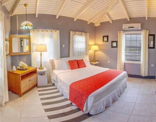 奥拉涅斯塔德Papaya Inn的一间卧室设有一张大床和两个窗户。