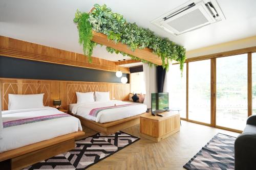 KiriwongPassion Resort Kiriwong的一间带两张床的卧室和一台电视