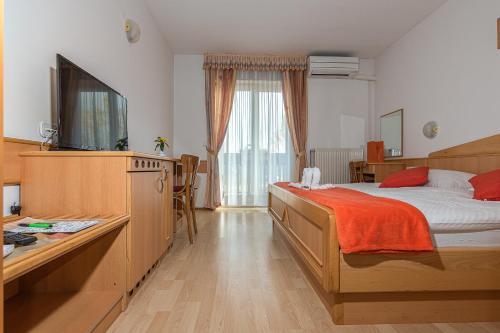 热尼亚波尔萨瓦歌乐埠酒店的一间卧室配有一张床和一台电视。