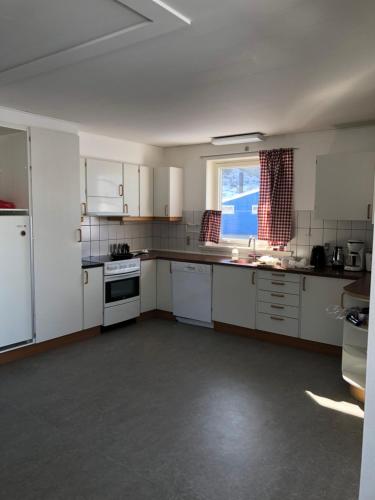 西西缪特isi4u hostel, dogsled, snowmobiling的一间设有白色橱柜和窗户的大厨房