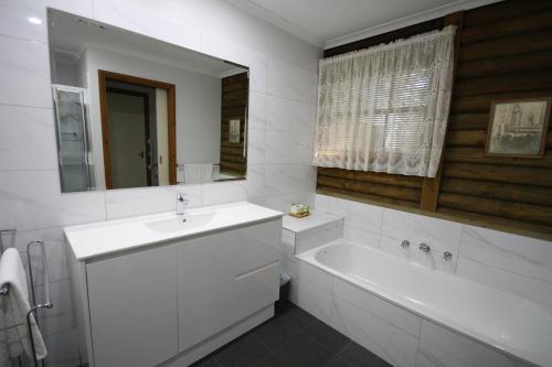 霍尔斯加普霍尔斯加普小屋度假酒店的一间带水槽、浴缸和镜子的浴室
